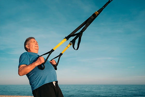 Homem praticando exercícios para a coluna, mais especificamente exercícios de fortalecimento para a coluna. 
